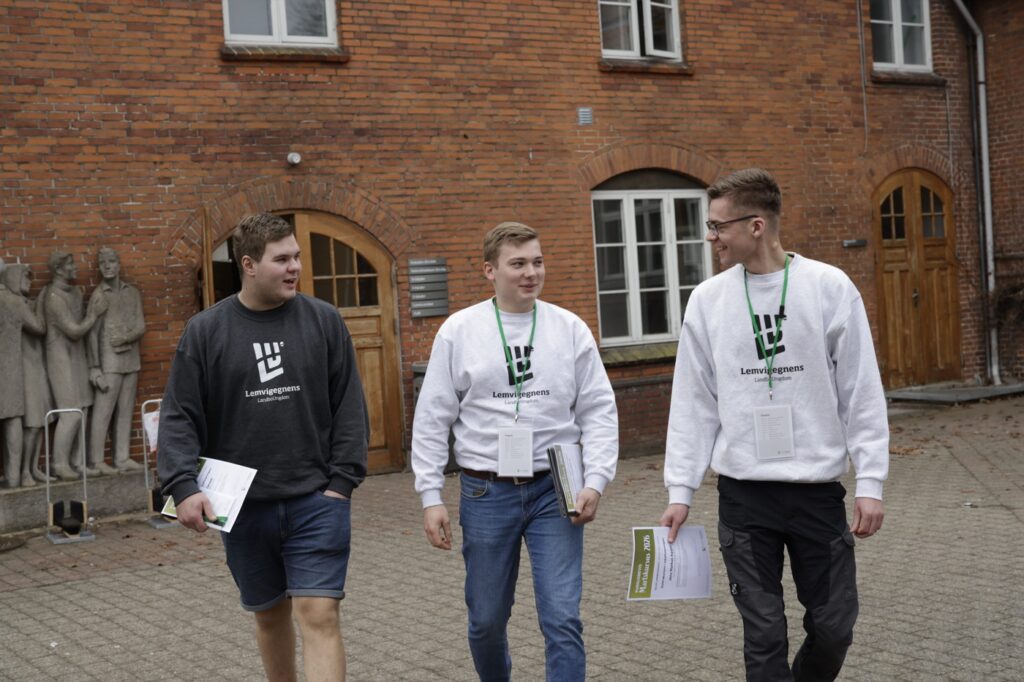 Tre unge fra LandboUngdom går sammen udenfor en gård